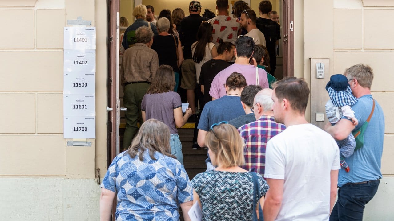 Wähler stehen zur Stimmabgabe bei den Kommunalwahlen in Sachsen vor einem Wahllokal an.
