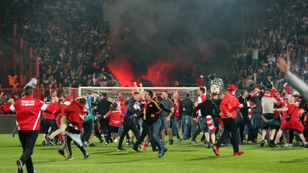 Die Fans von Union Berlin stürmen nach dem Aufstieg den Platz.