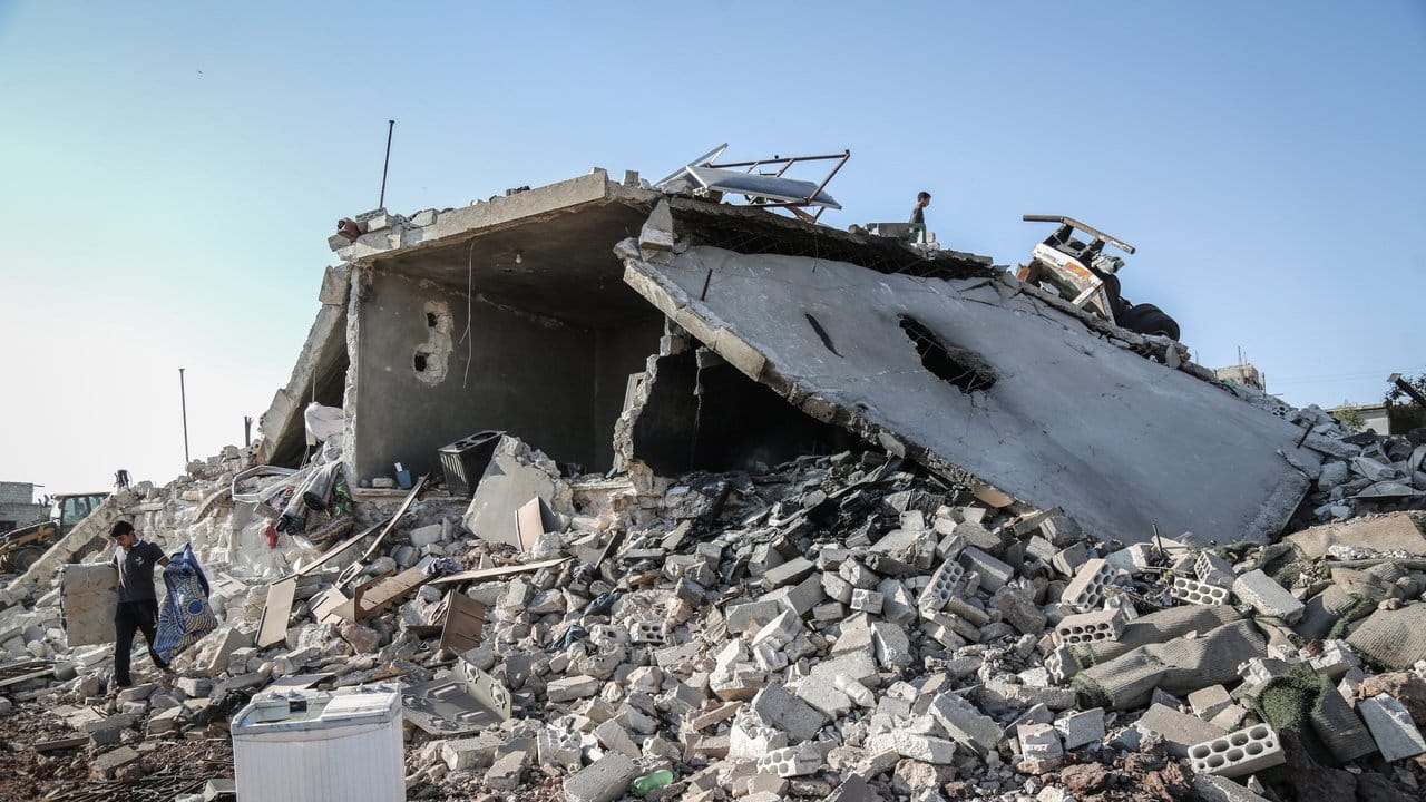 Menschen retten Brauchbares aus den Trümmern eines Gebäudes, das durch nächtliche Luftangriffe auf Wohngebiete in der Provinz Idlib zerstört wurde.