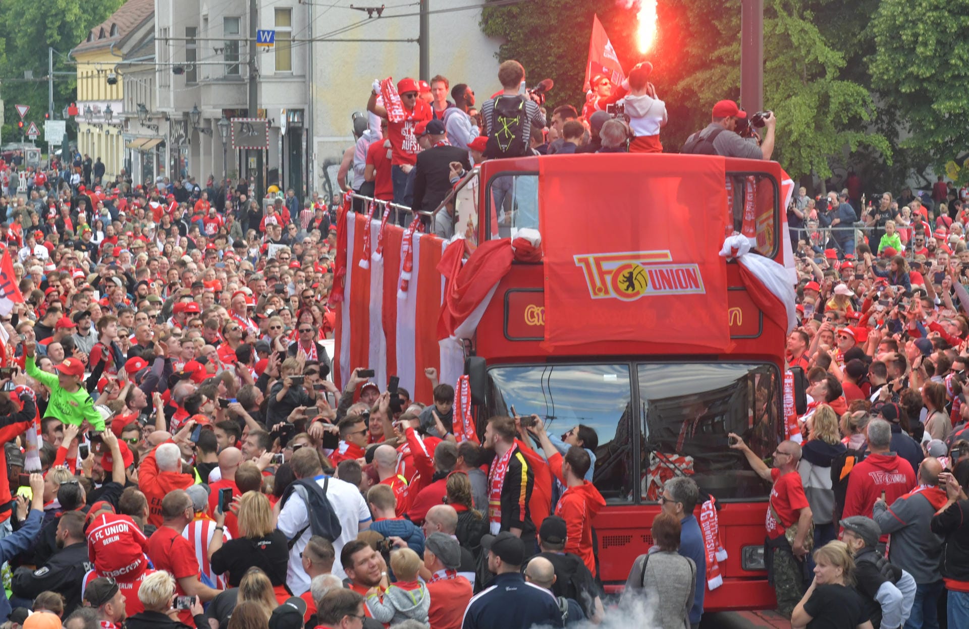Rot-Weißes Partykommando: Der Bus bahnt sich seinen Weg durch die Menge.