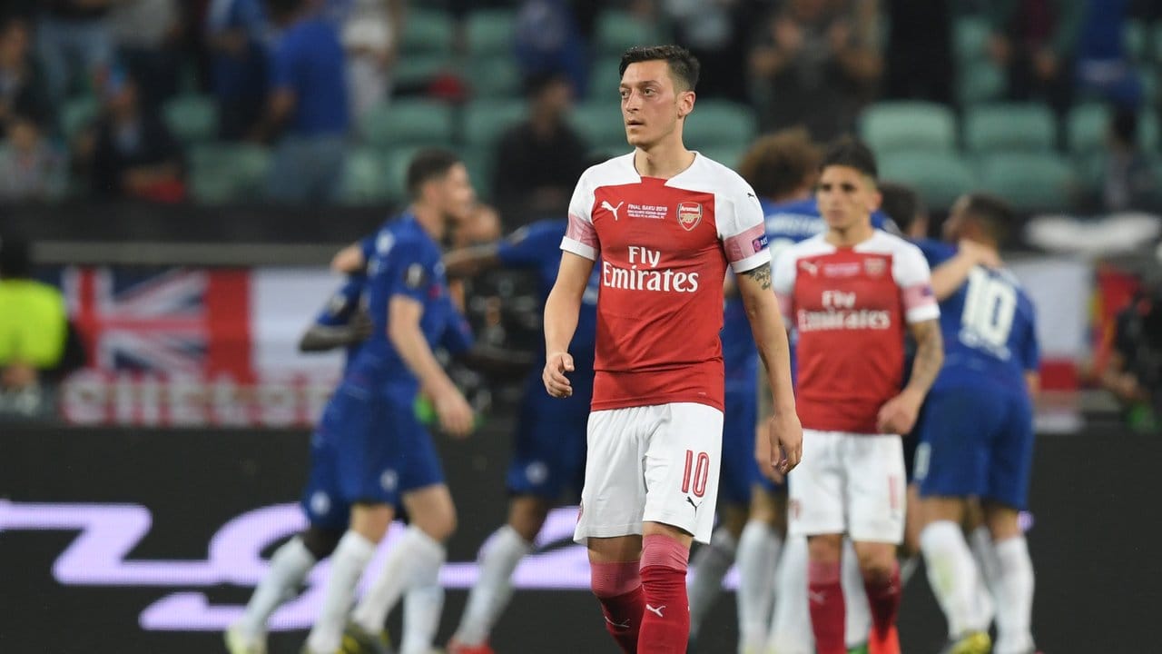 Während die Chelsea-Profis das Tor zum 1:0 feiern, schaut Arsenals Mesut Özil enttäuscht drein.