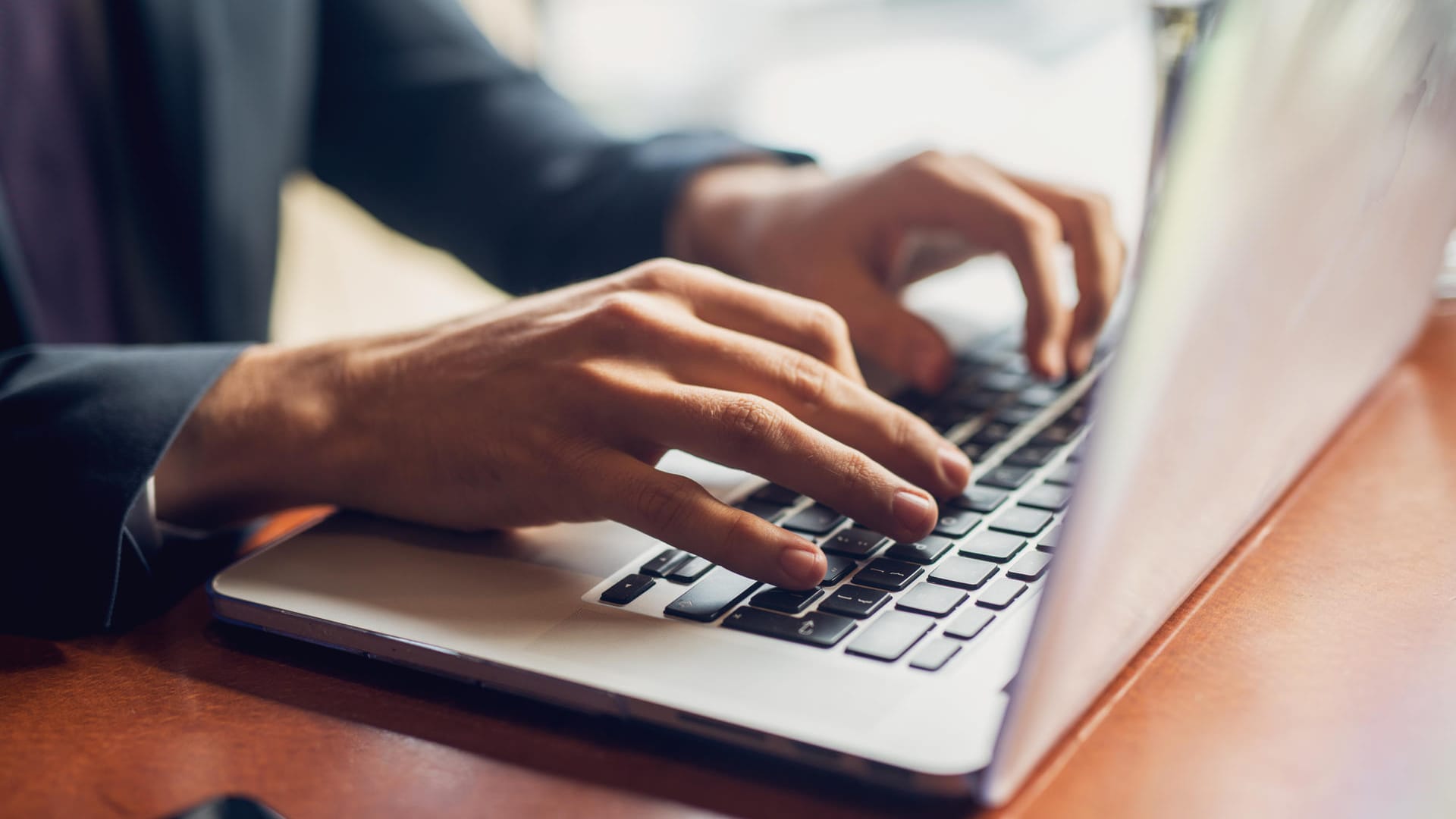 Ein Mann tippt auf einer Notebook-Tastatur