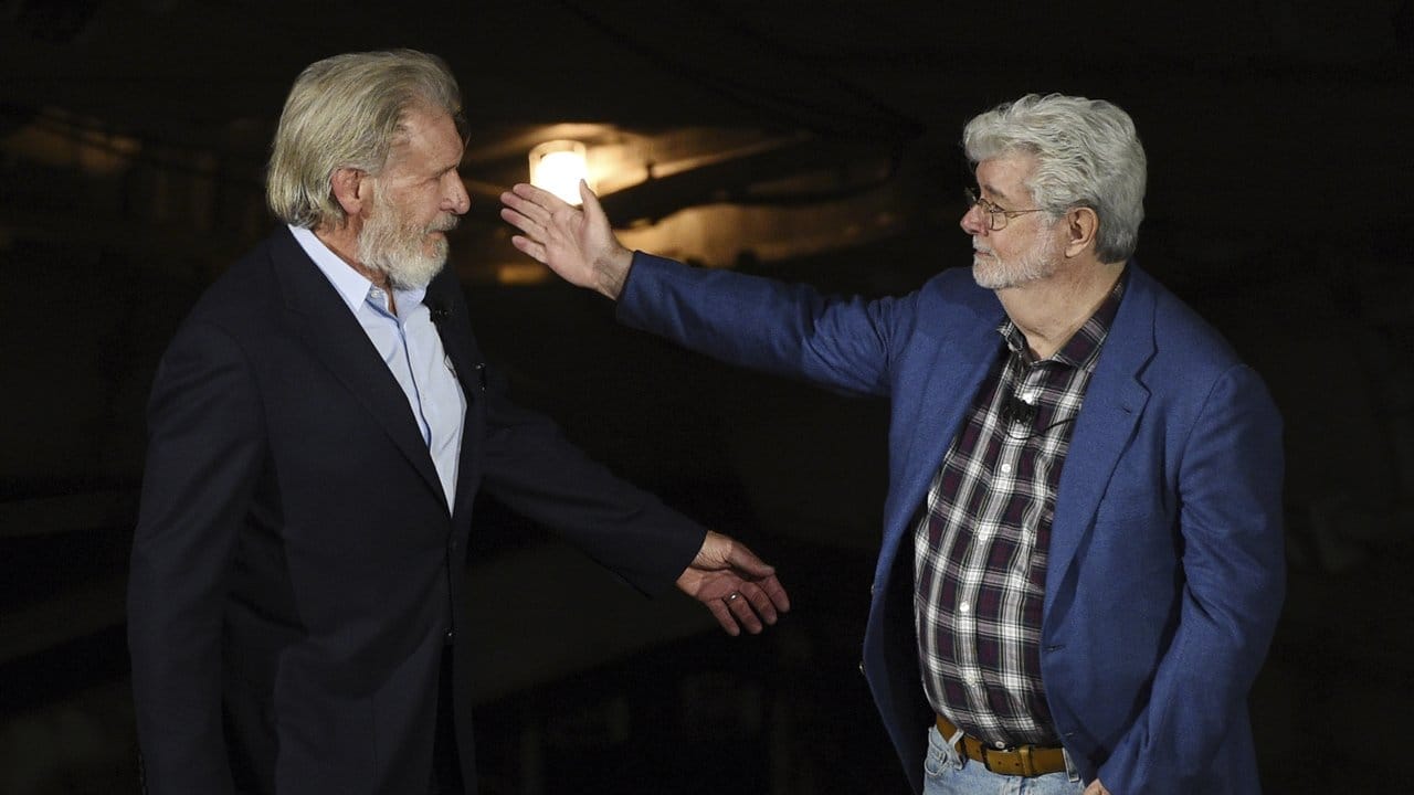 George Lucas (r) begrüßt Harrison Ford bei der Eröffnungsfeier des "Star Wars: Galaxy's Edge"-Themenparks.