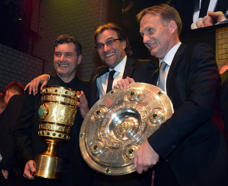 Ein Jahr später legen Klopp und der BVB nach. Der Meistertitel wird verteidigt, zudem gelingt der Sieg im DFB-Pokal. Mit 5:2 werden die Bayern demontiert, Klopp feiert mit den BVB-Bossen Michael Zorc (links) und Hans-Joachim Watzke das Double.