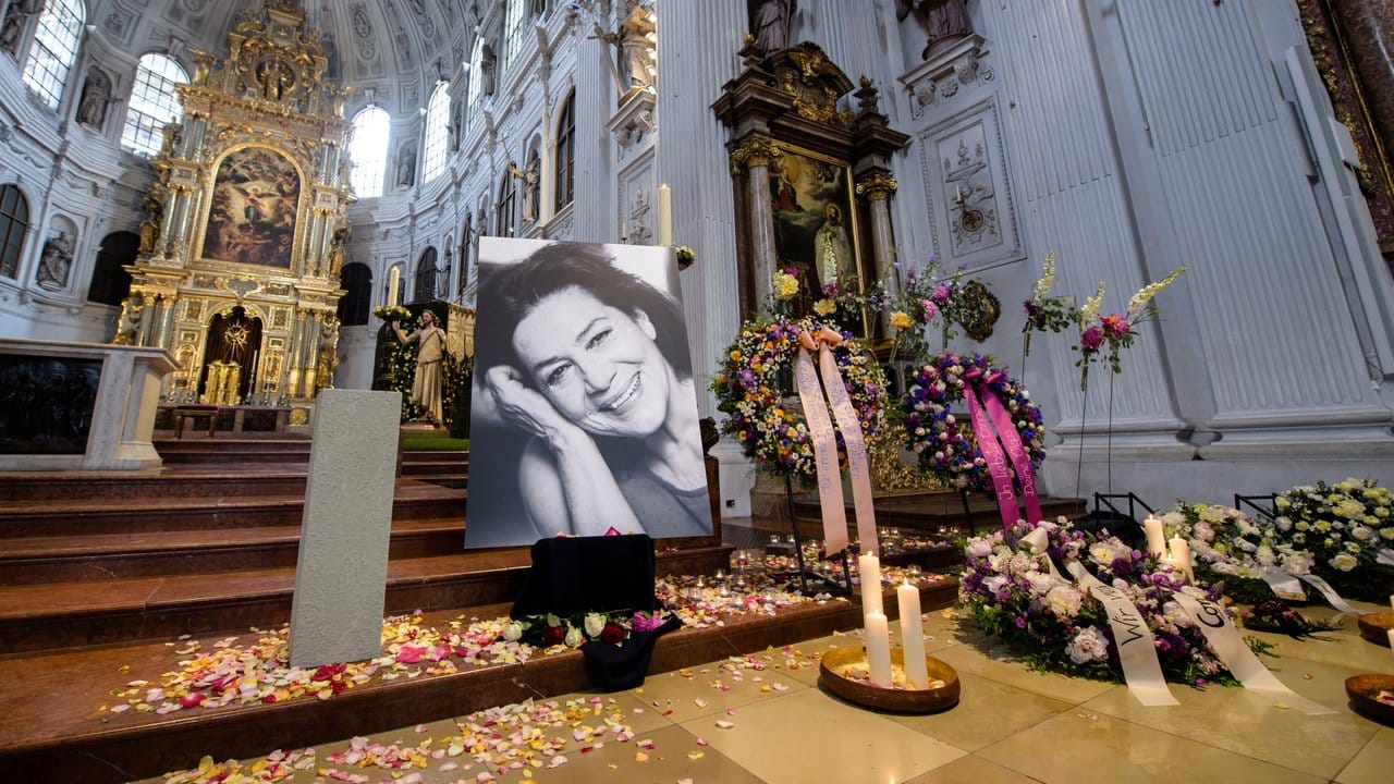 Kerzen, Blütenblätter, Kränze und ein Porträt von Hannelore Elsner in der Kirche St. Kerzen, Blütenblätter, Kränze und ein Porträt von Hannelore Elsner in der Kirche St.