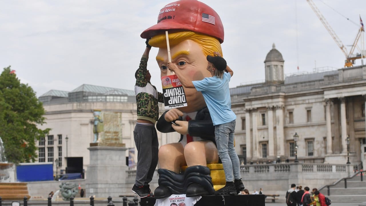 So sehen ihn manche Briten: Ein knapp 5 Meter großer sprechender Roboter, in der Anmutung von US-Präsident Trump sitzt am Trafalgar Square auf einer Goldtoilette.