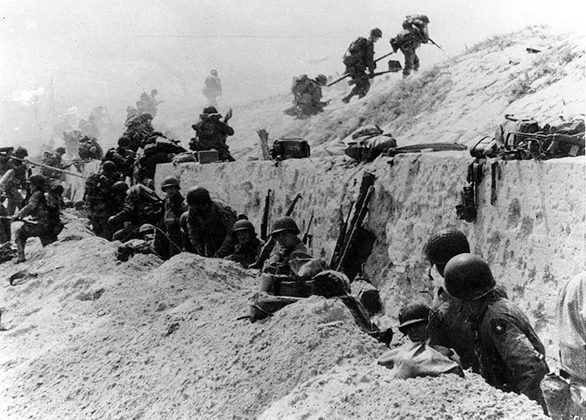 US-Soldaten klettern über eine Betonwand am Strand in der Nähe der kleinen Ortschaft La Madeleine: Um 9.30 Uhr gab General Eisenhower in der BBC die Landung der Alliierten in der Normandie offiziell bekannt.