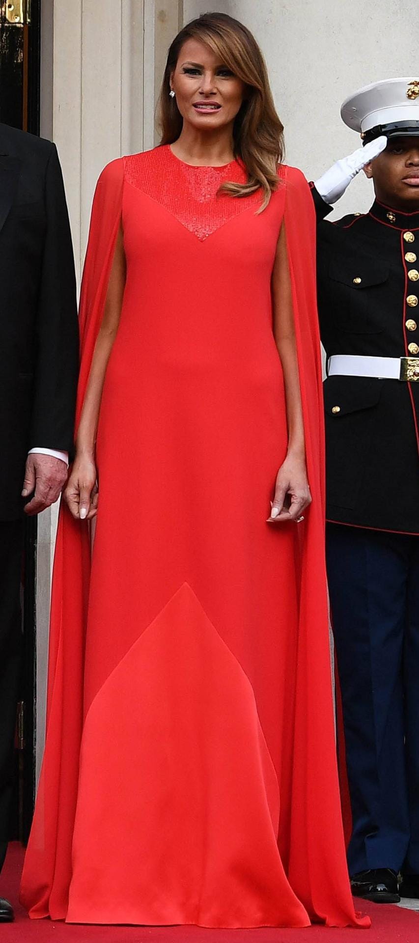 Melania diesmal in knalliger Signalfarbe: Die 49-Jährige trägt eine auffällige rote Robe von Givenchy. Beim Dinner in London fällt sie mit ihrem Cape-Kleid auf.