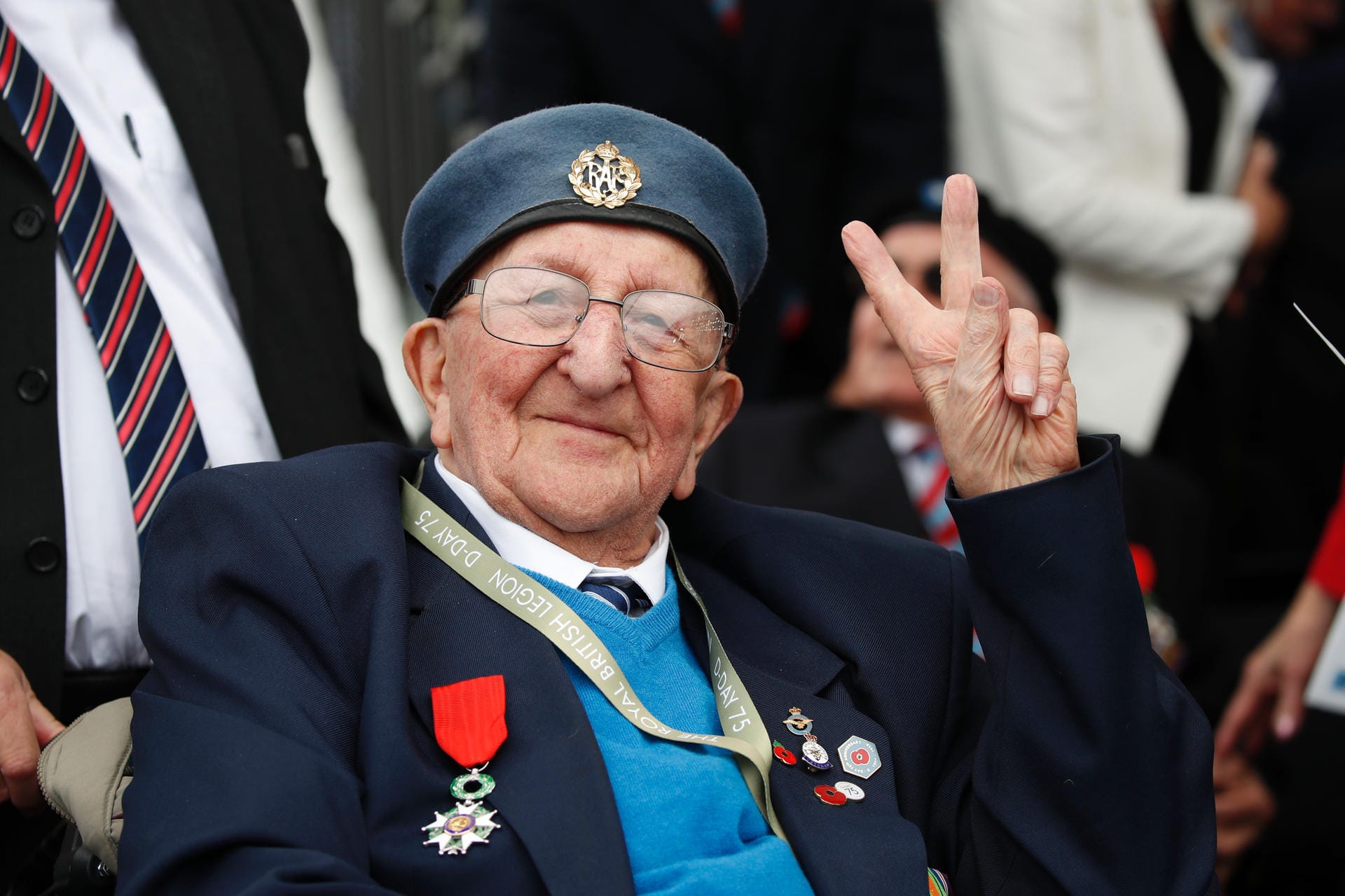 Ein Veteran des D-Day macht das Victory-Zeichen.