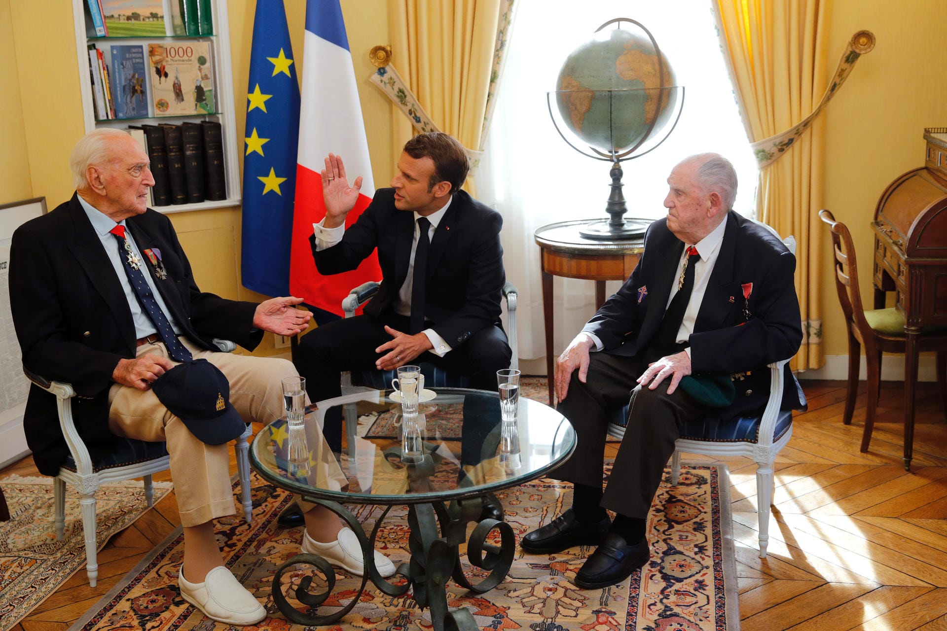 Frankreichs Präsident Emmanuel Macron traf sich mit zwei Veteranen, Leon Gautier (re.) und Jacques Lewis in Bayeux zum Gespräch.