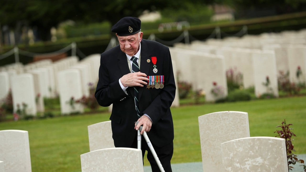 Ein Weltkriegsveteran bekreuzigt sich auf dem Soldatenfriedhof von Bayeux zum 75.