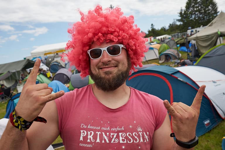 Rockfan Paul tanzt mit rosa Perücke auf dem Campinggelände des Open-Air-Festivals "Rock am Ring".