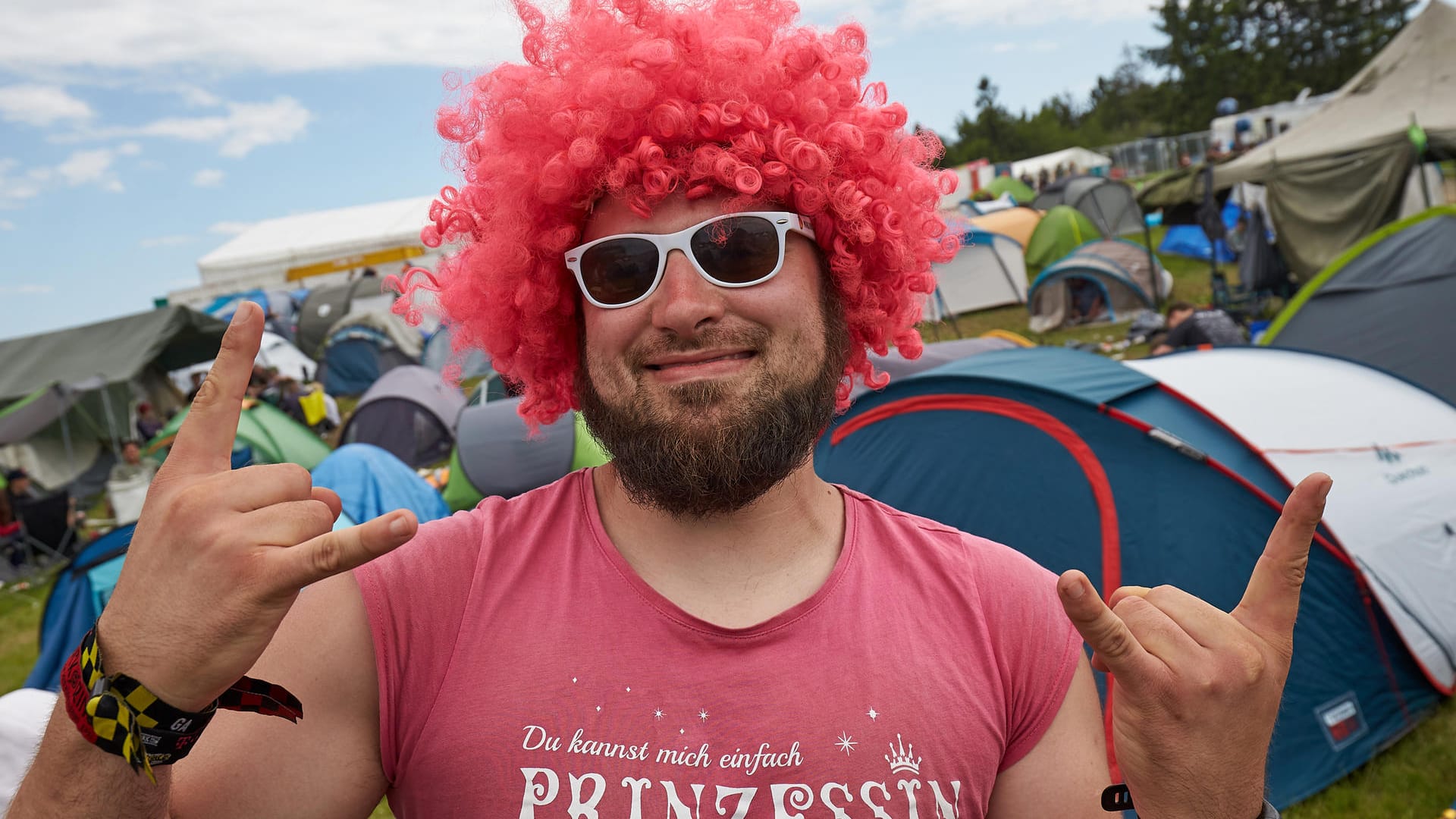 Rockfan Paul tanzt mit rosa Perücke auf dem Campinggelände des Open-Air-Festivals "Rock am Ring".