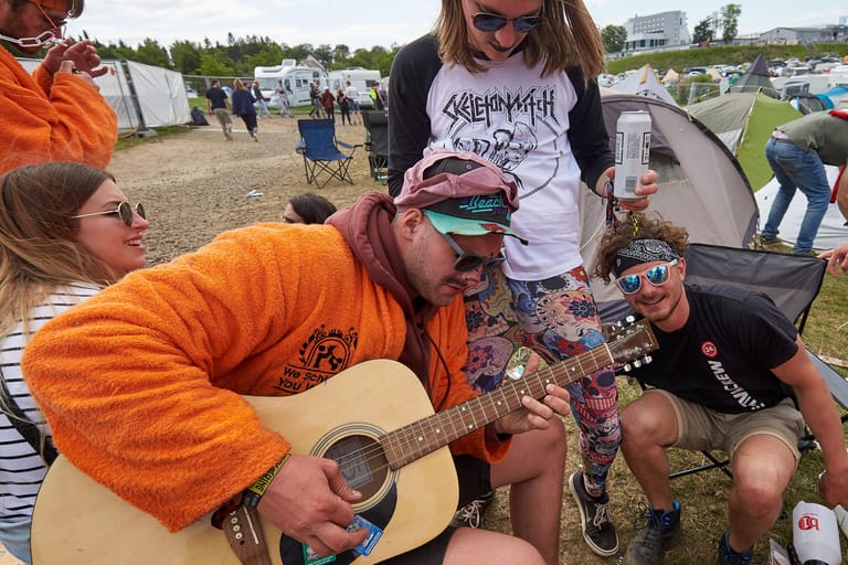 Rockfan Georg spielt auf dem Campinggelände Gitarre. An drei Tagen treten rund 75 Bands auf drei Bühnen vor mehr als 80000 Zuschauern auf.