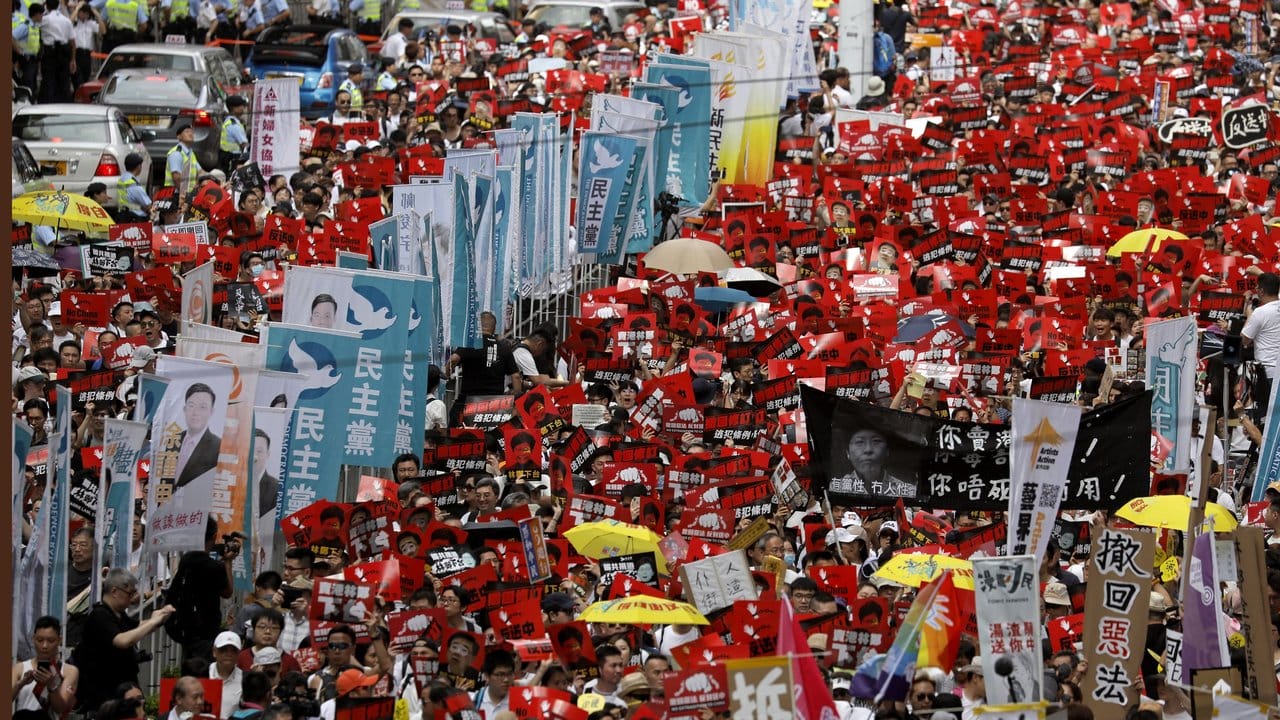 Bei einer Massen-Kundgebung in Hongkong tragen die Teilnehmer Fahnen und Plakate.
