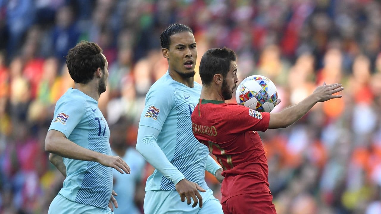 Portugals Bernardo Silva (r) nimmt den Ball vor Virgil Van Dijk mit der Brust an.