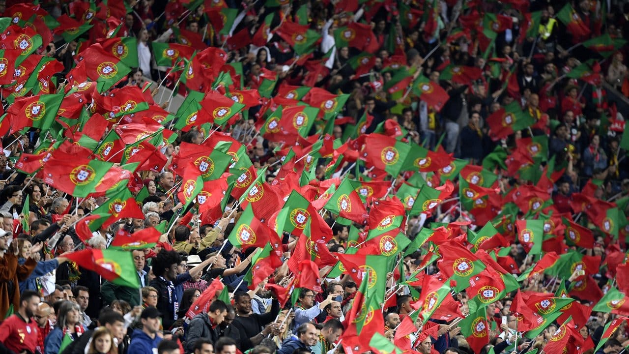 Die portugiesischen Fans schwenken auf der Tribüne ihre Nationalfahnen.