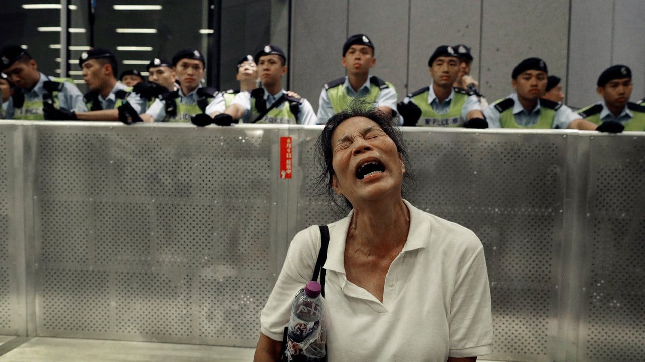 Eine Frau reagiert während Demonstranten und Polizisten während eines Protests gegen das von der Regierung geplante Auslieferungsgesetz zusammenstoßen.