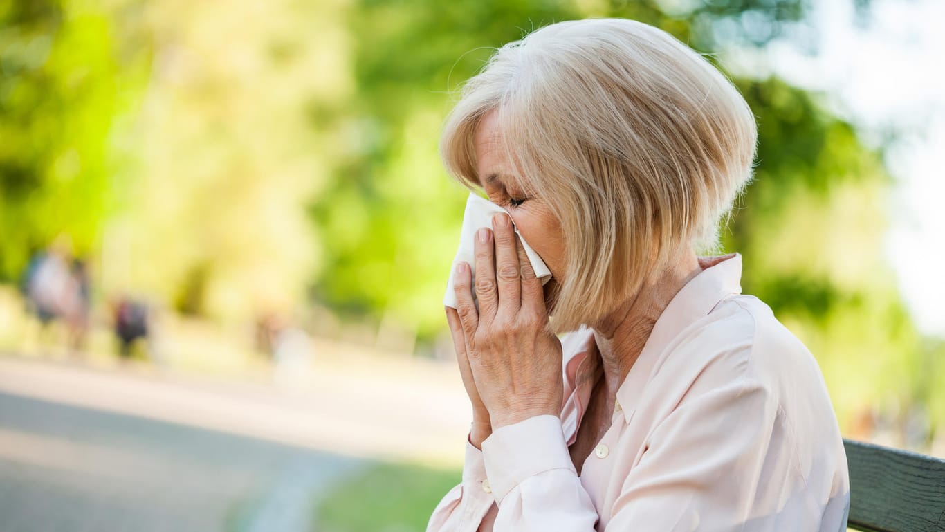 Eine Frau putzt ihre Nase: Sind Sie an einer Sommergrippe erkrankt, sollten Sie sich etwa eine Woche lang schonen.