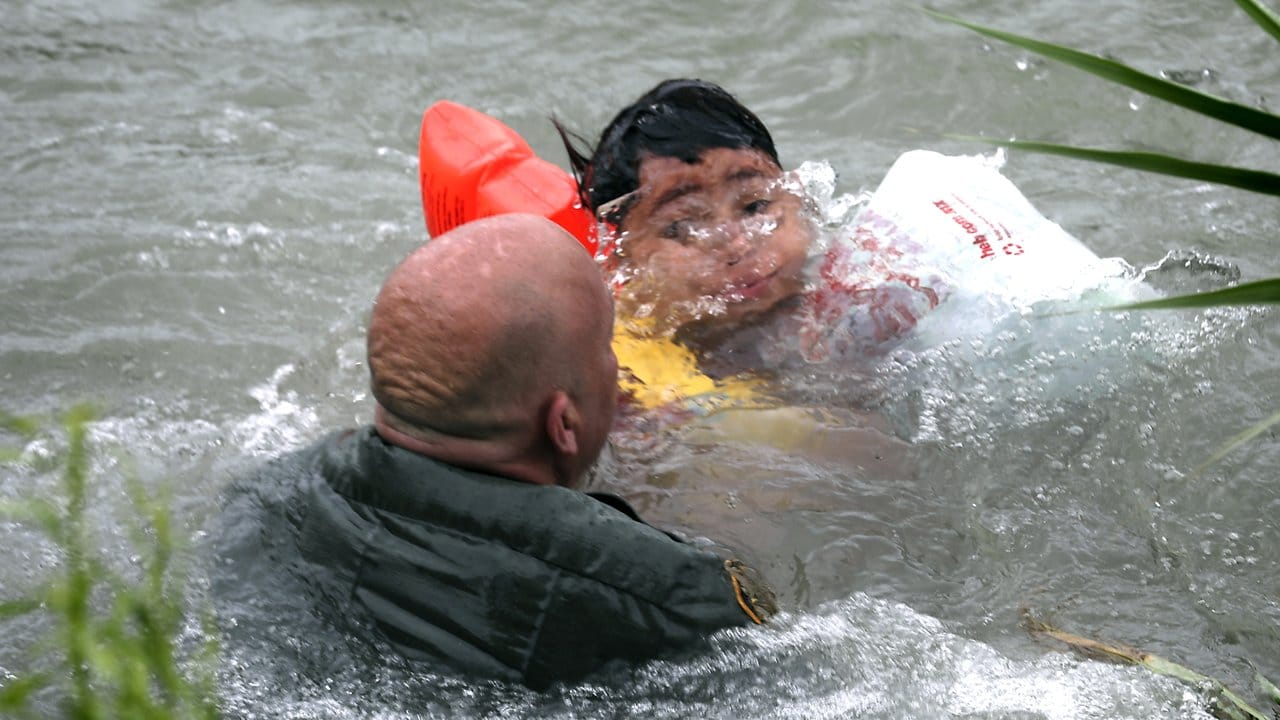 Ein US-Grenzschutzbeamter hilft einem Jungen aus Honduras, nachdem er von einem Floß in den Grenzfluss Rio Grande gefallen ist.