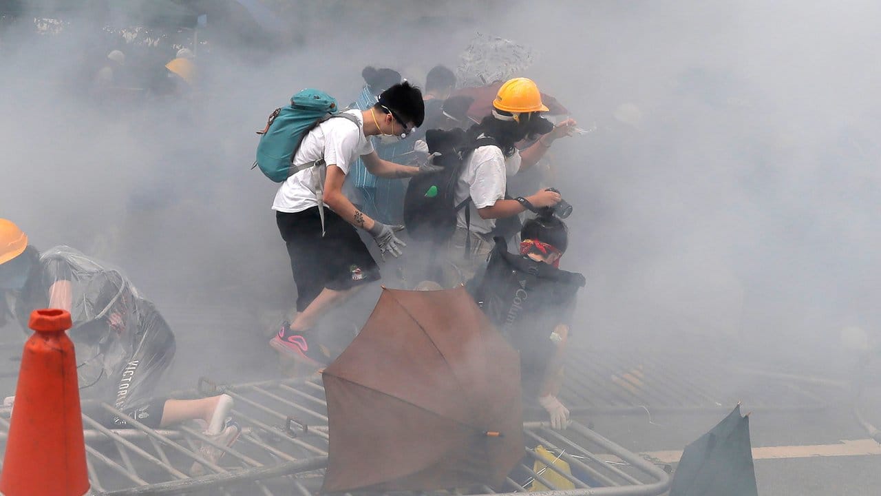 Demonstranten schützen sich mit Gesichtsmasken vor dem Tränengas der Hongkonger Sicherheitskräfte.