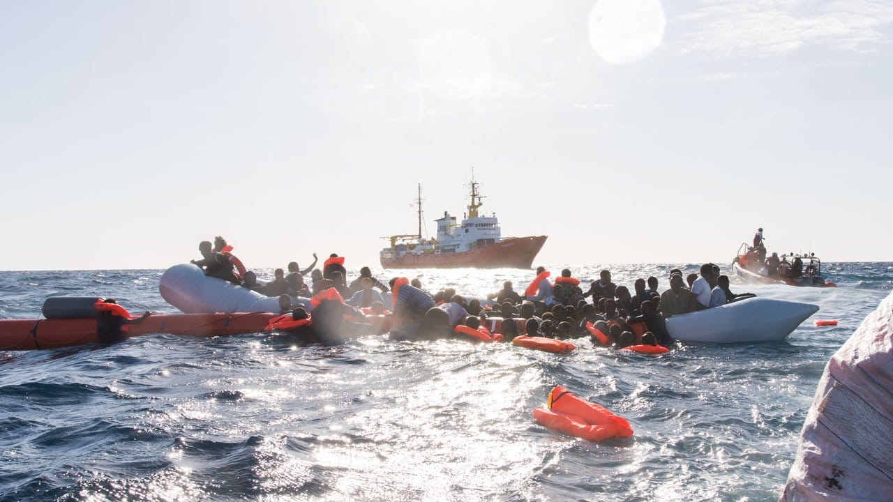 Flüchtlinge, die auf Booten von Libyen aus nach Italien übersetzen wollten, werden während eines Rettungseinsatzes vor der nordafrikanischen Küste geborgen.