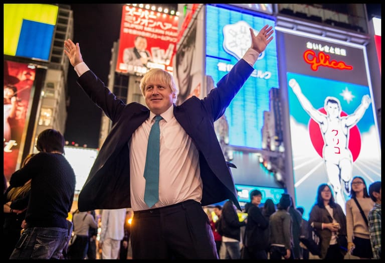 Große Ambitionen: Boris Johnson macht bei einem Besuch in einer Einkaufsstraße in Osaka eine Geste.