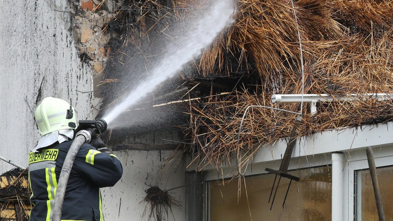Ein Feuerwehrmann löscht Glutnester im Dachstuhl des ausgebrannten Ostseehotels. Ein Feuerwehrmann löscht Glutnester im Dachstuhl des ausgebrannten Ostseehotels.
