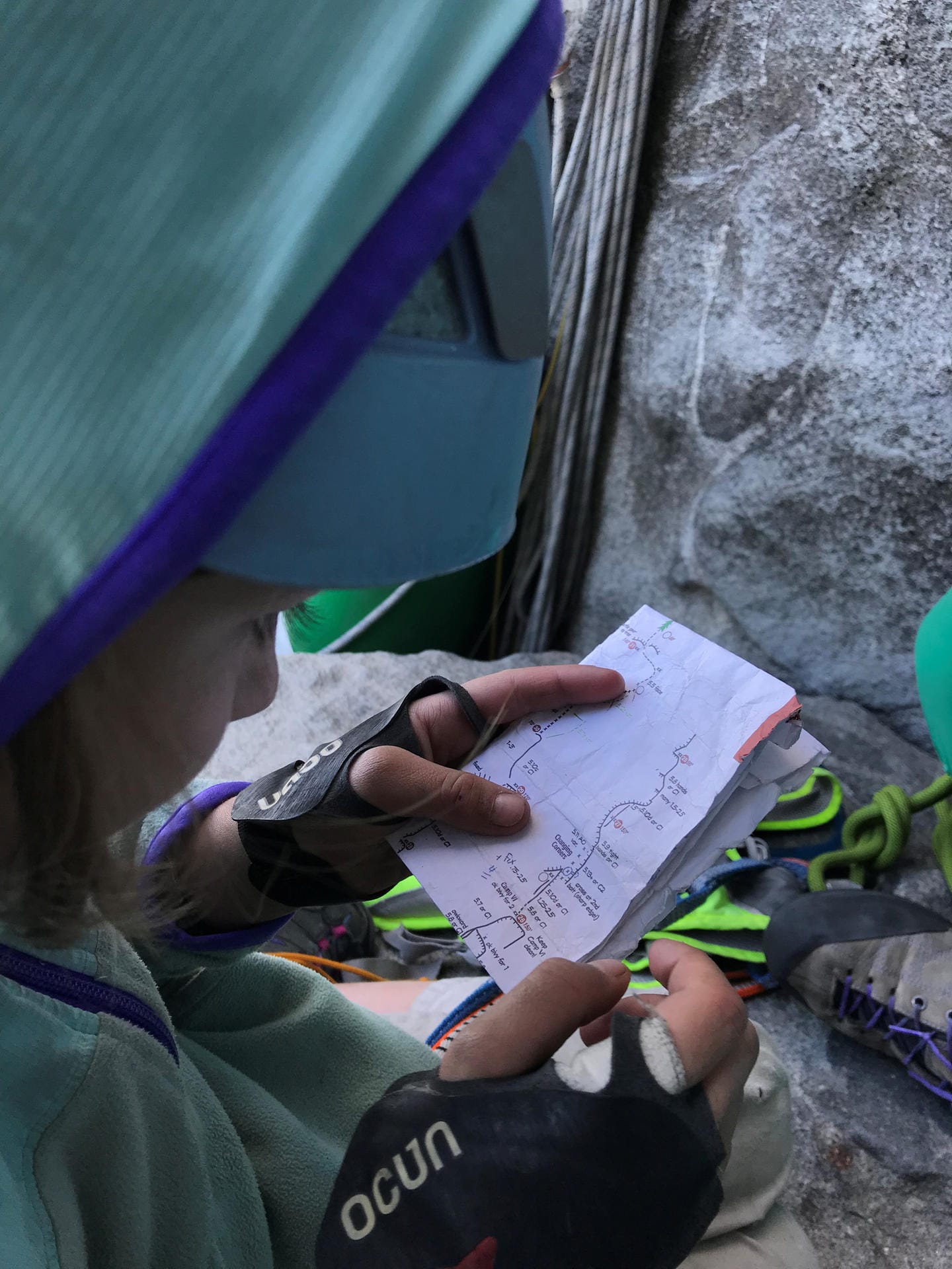 Selah Schneiter schaut sich ihre Notizen an. Ihr Vater erklärt ihr Schritt für Schritt, was sie beim Klettern beachten soll.