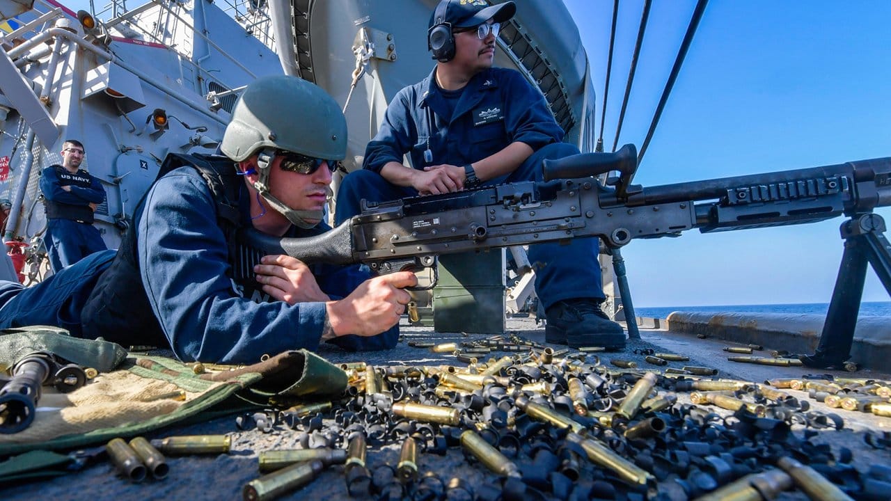 An Bord des Zerstörers USS Mitscher im Golf von Oman hält ein US-Soldat ein Maschinengewehr im Anschlag.