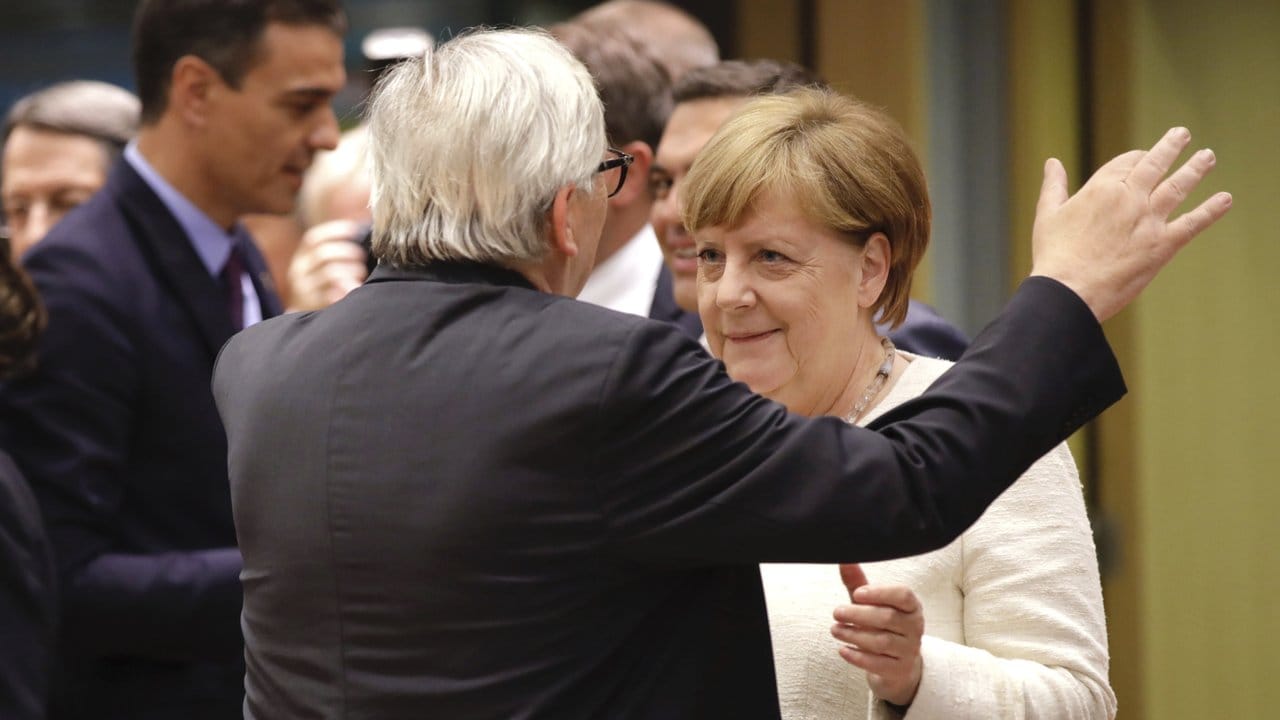 Bundeskanzlerin Angela Merkel und EU-Kommissionspräsident Jean-Claude Juncker, begrüßen sich.