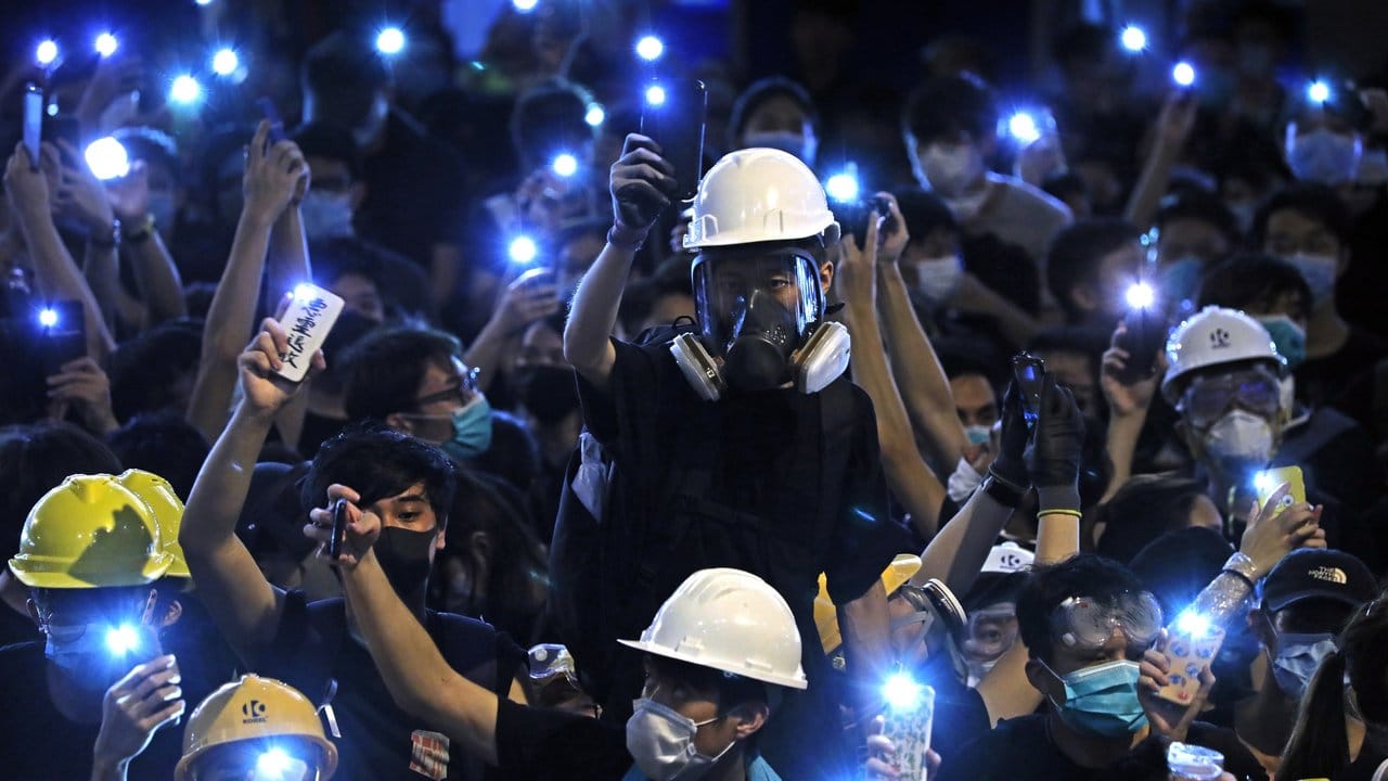 Demonstranten leuchten mit dem Licht ihre Handys vor dem Polizeipräsidium von Hongkong.