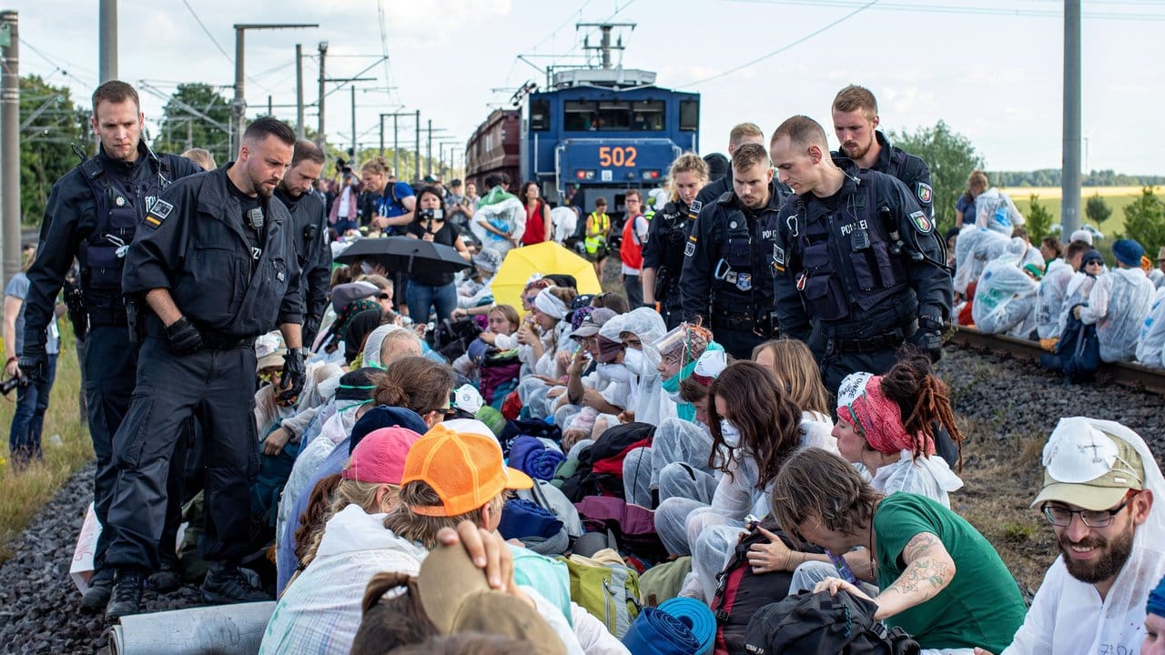 Unter Polizeibeobachtung aus nächster Nähe: Aktivisten blockieren am Freitag die Gleise der Kohle-Transportbahn. Unter Polizeibeobachtung aus nächster Nähe: Aktivisten blockieren am Freitag die Gleise der Kohle-Transportbahn.