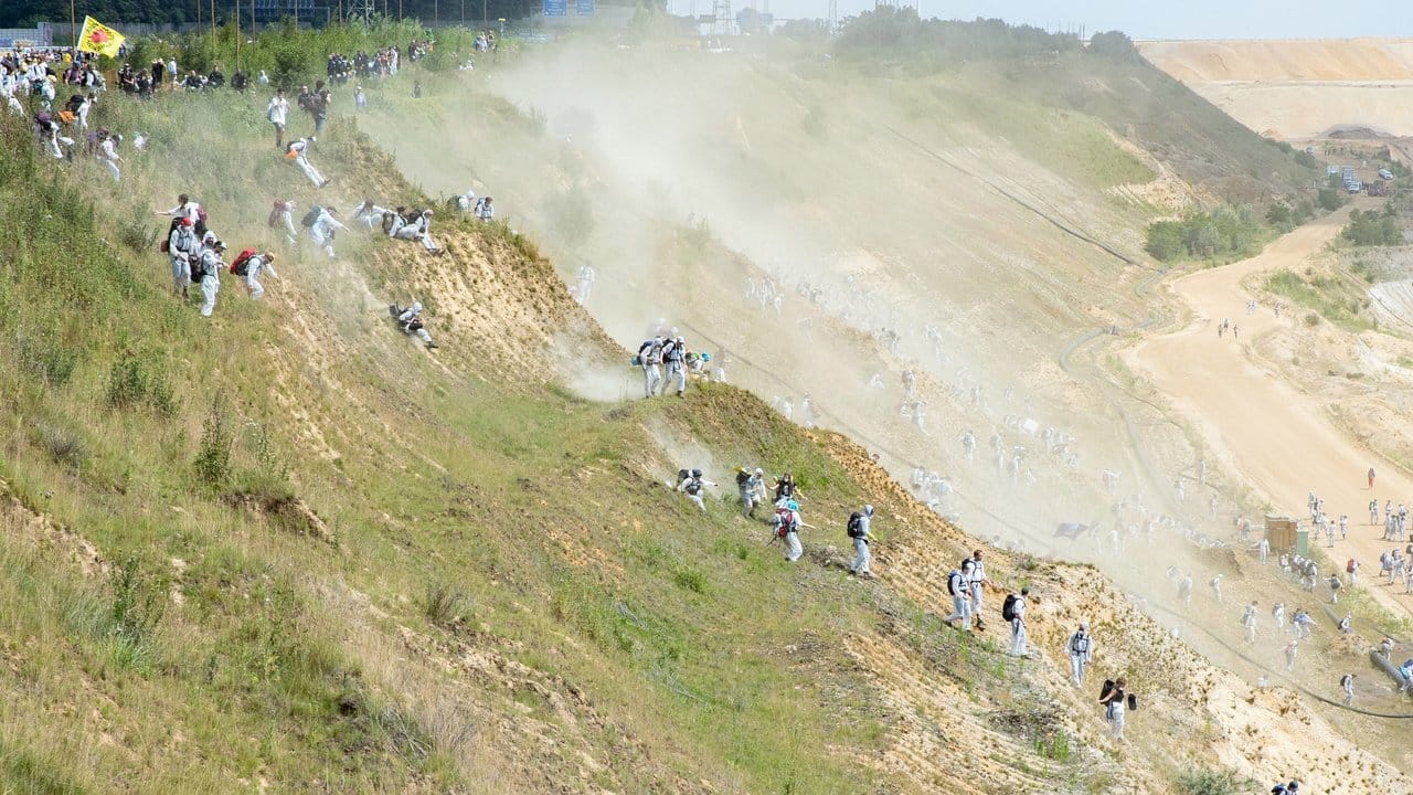 Zahlreiche Umweltaktivisten laufen in den Tagebau Garzweiler, nachdem sie die Polizeisperre durchbrochen haben.