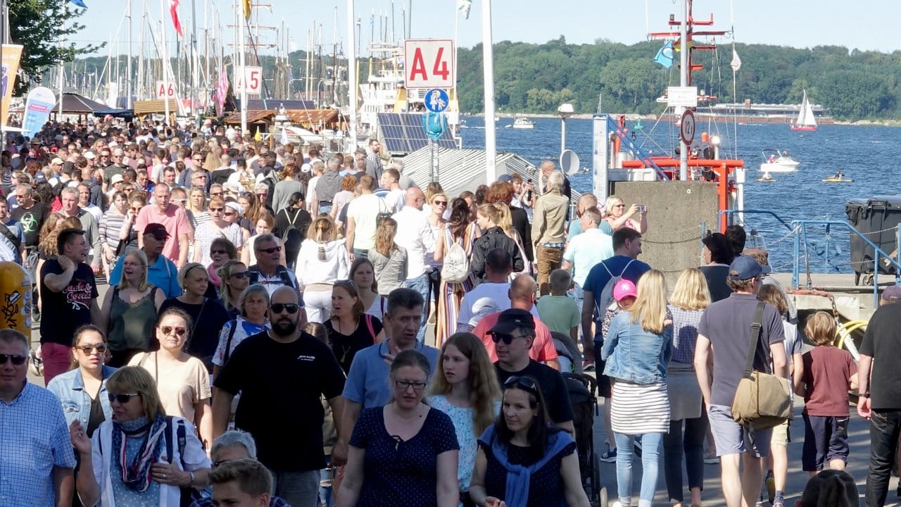 Tausende von Menschen gehen am ersten Tag der Kieler Woche über die Kiellinie.