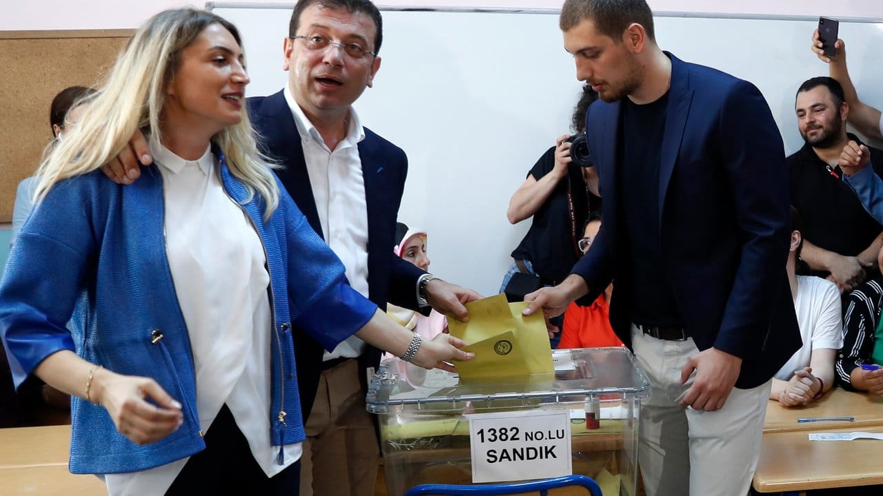 Ekrem Imamoglu (M) mit seiner Frau Dilek (l) und seinem Sohn bei der Stimmabgabe.