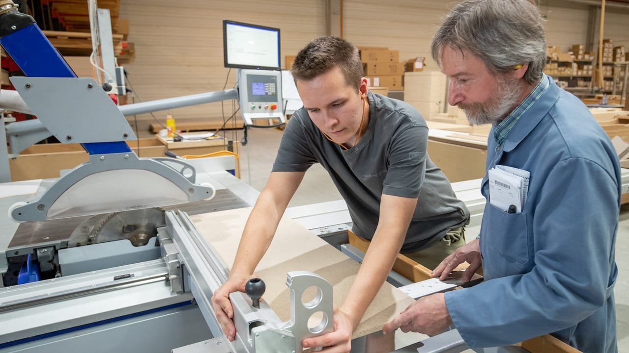 Lärm und Schmutz sind bei der Arbeit als Holzmechaniker tägliche Begleiter: Meißner kümmert sich an der Kreissäge zusammen mit seinem Ausbilder Joachim Seitz um den Zuschnitt einer Tür.