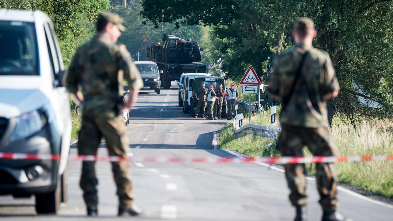 Zwei Soldaten stehen an einer Straßensperre in der Nähe eines Waldgebiets bei Nossentin, wo einer der beiden Eurofighter abgestürzt ist.