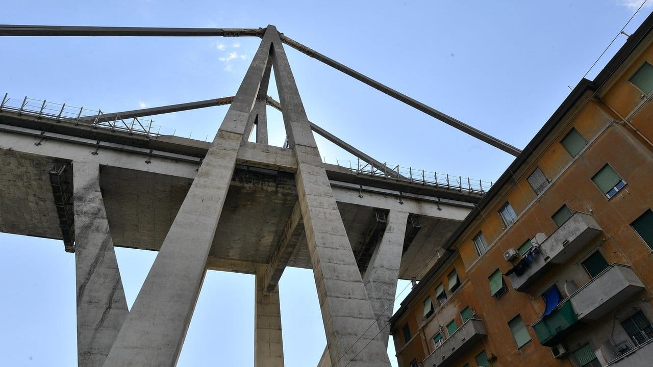 Blick auf die teilweise eingestürzte Morandi-Autobahnbrücke über einem evakuierten Wohnhaus. Blick auf die teilweise eingestürzte Morandi-Autobahnbrücke über einem evakuierten Wohnhaus.