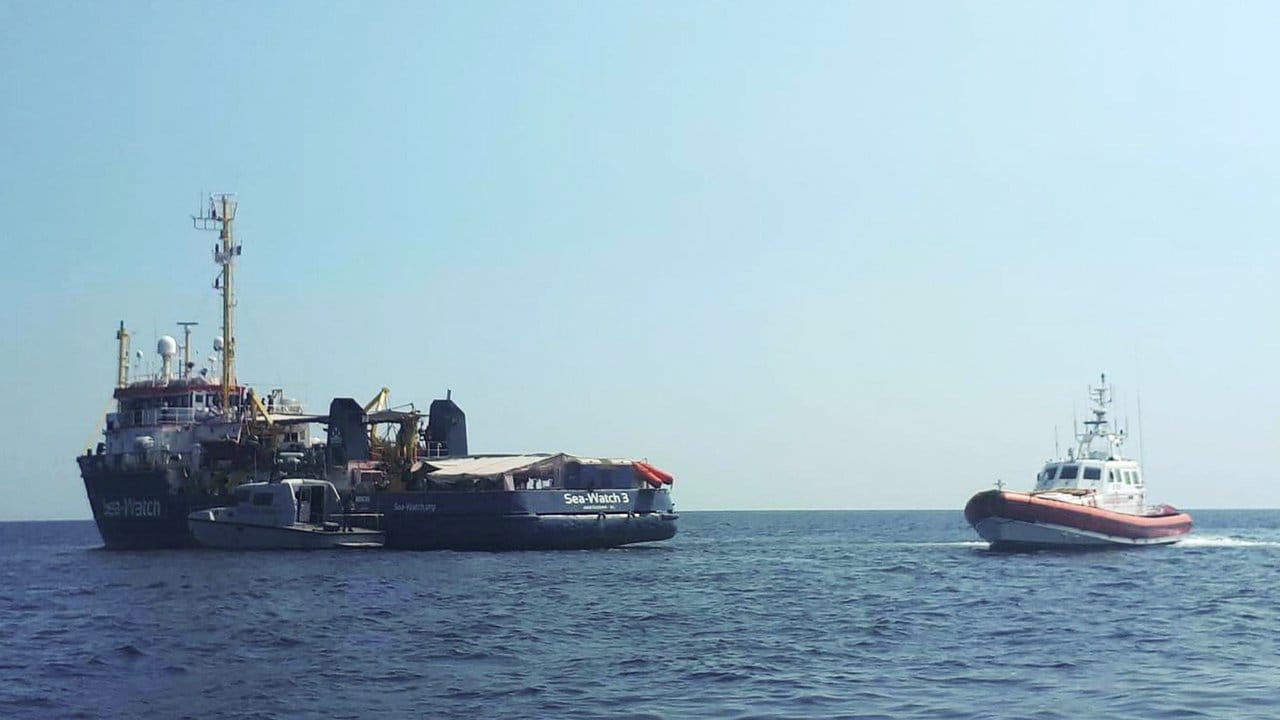Ein Boot der italienischen Küstenwache patrouilliert neben dem Rettungsschiff "Sea-Watch 3" vor der Küste der süditalienischen Insel Lampedusa.