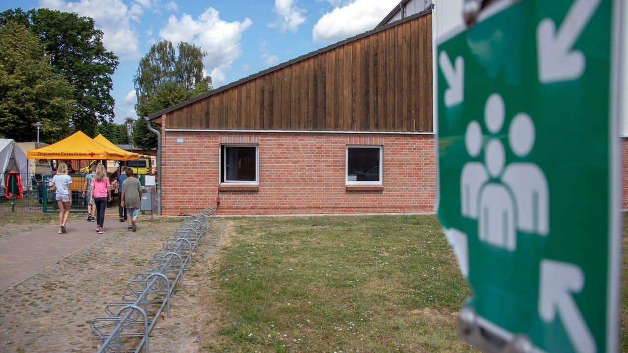 Kinder gehen in die Notunterkunft in einer Mehrzweckhalle. Kinder gehen in die Notunterkunft in einer Mehrzweckhalle.