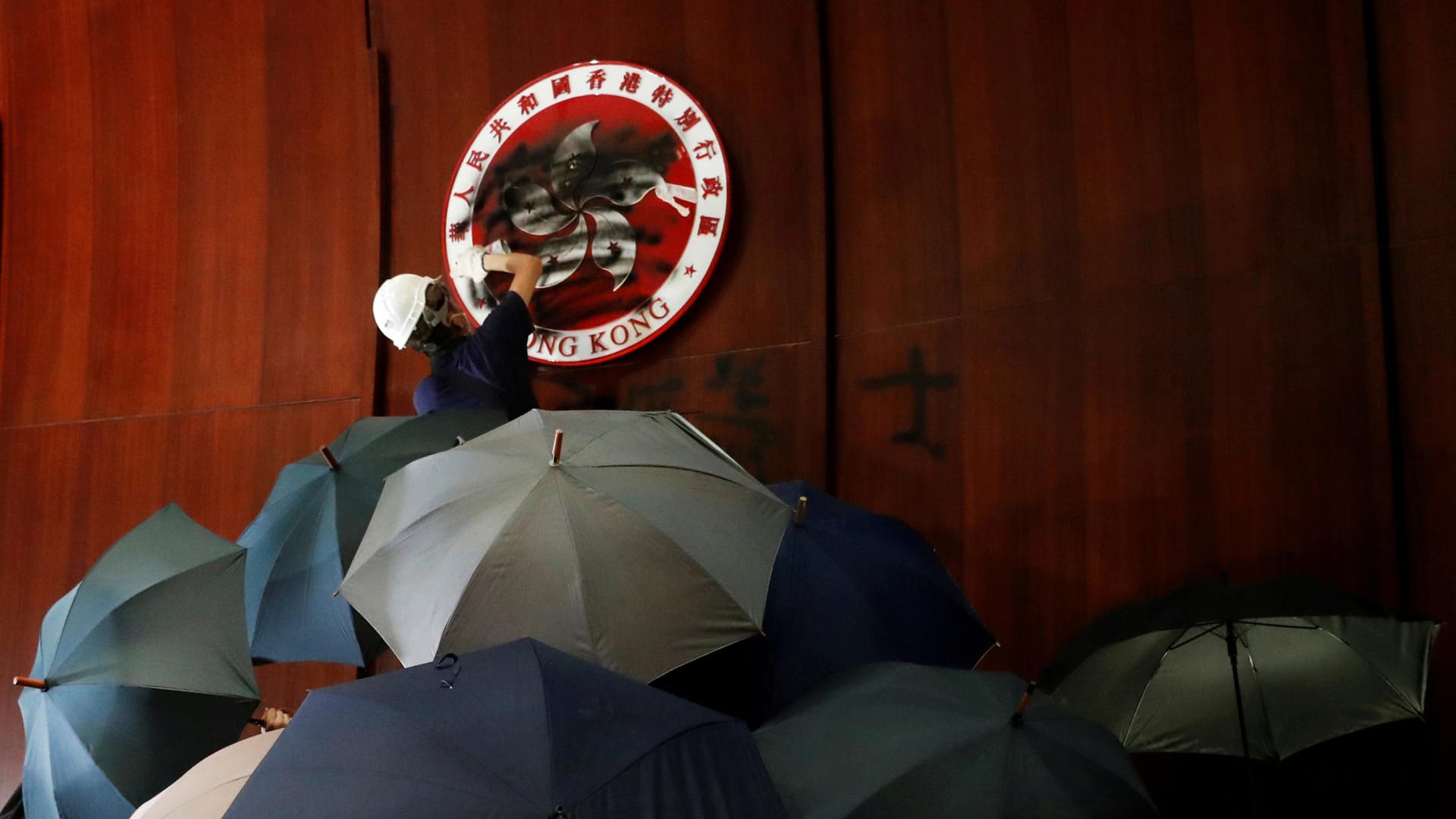 Demonstrant übersprüht das Wappen Hongkongs im Parlament: Am Jahrestag der Übergabe des Stadtstaats von Großbritannien an China sind die Proteste eskaliert.