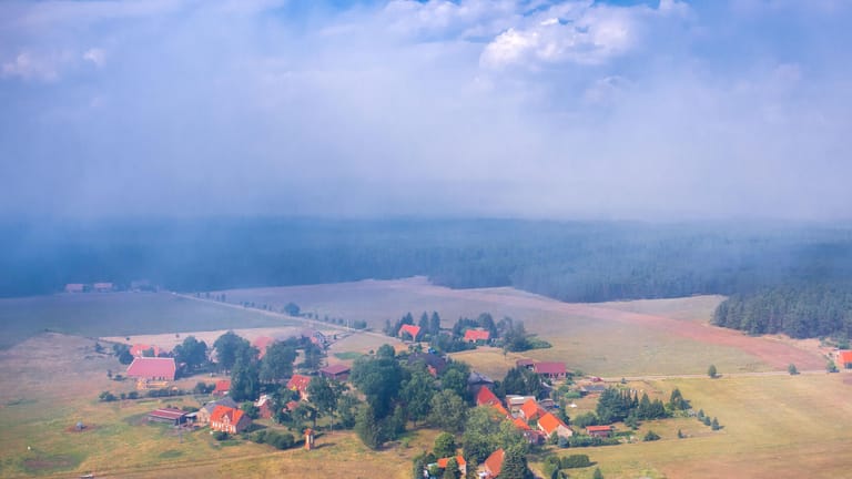 Rauchwolken ziehen über die kleine Ortschaft Hohen Woos am Rande des ehemaligen Truppenübungsplatzes.