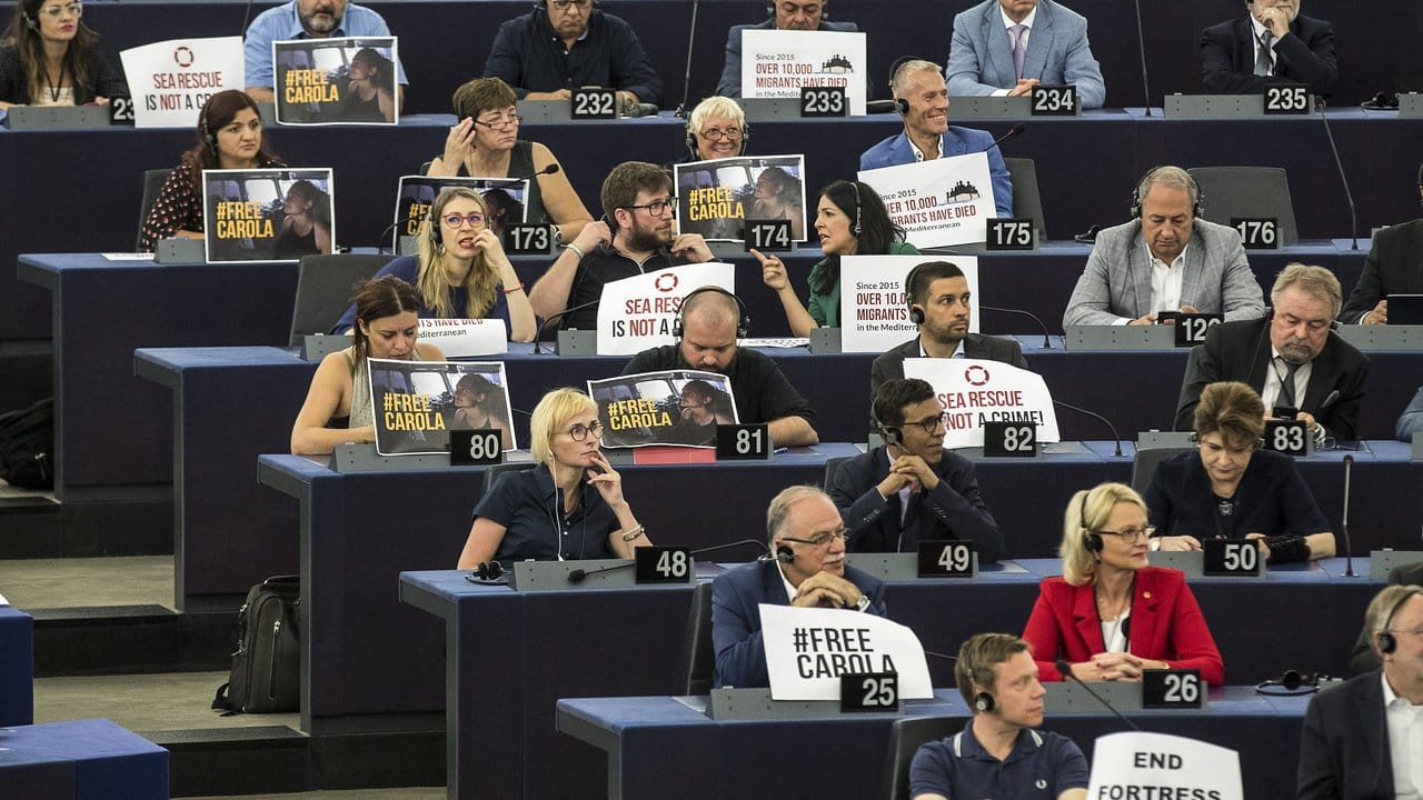 "Seenotrettung ist kein Verbrechen" - Mitglieder des EU-Parlaments zeigen Schilder zur Unterstützung der Kapitänin des Rettungsschiffes "Sea-Watch 3".