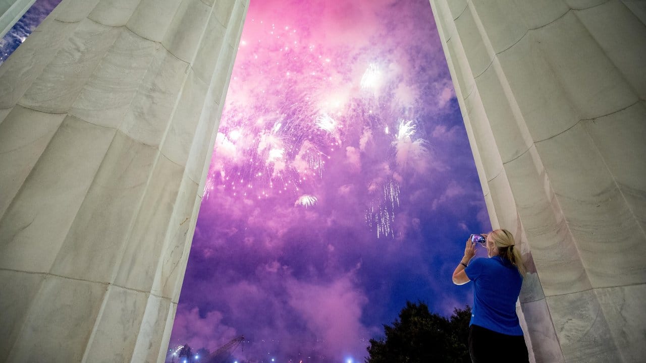 Eine Frau verfolgt das Feuerwerk über dem Lincoln Memorial.