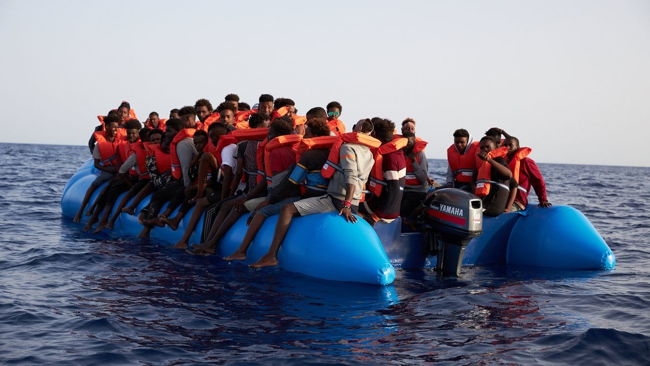 Flüchtlinge sitzen vor der Küste von Libyen in einem Schlauchboot, bevor sie vom Hilfsschiff "Alan Kurdi" gerettet werden.