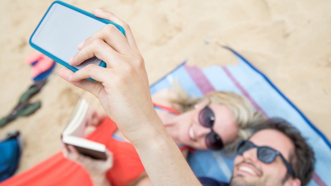 Beim Selfie am Sandstrand steckt das Smartphone lieber in einer Schutzhülle.