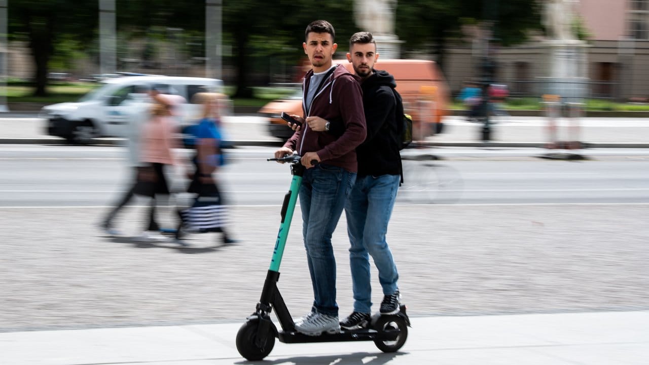 Auch das ist verboten: Touristen fahren zu zweit auf einem E-Roller durch Berlin-Mitte.