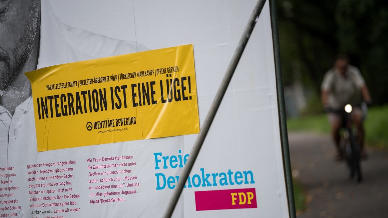 Ein Aufkleber der rechten Identitären Bewegung klebt auf einem Wahlplakat der FDP in Tübingen.