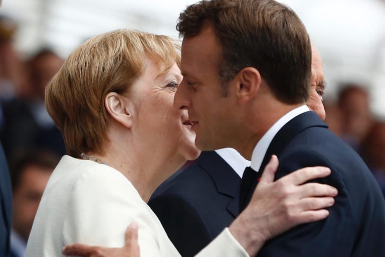 Begrüßung mit Küsschen: Bundeskanzlerin Merkel und Frankreichs Präsident Macron am Sonntag in Paris.